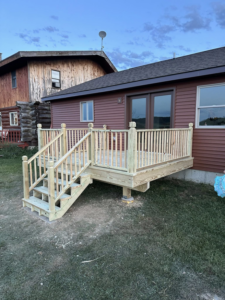 A newly constructed wooden deck with stairs and railings by Next Generation Carpentry LLC in Bennington, VT.