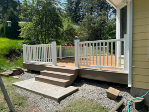 A newly constructed outdoor deck with white railings and steps by Royal Construction & Remodeling, Inc. in Lake Charles, LA.