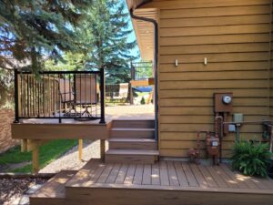 A newly constructed outdoor deck with stairs and black railing by Vander Wal Contracting, LLC in Bismarck, ND