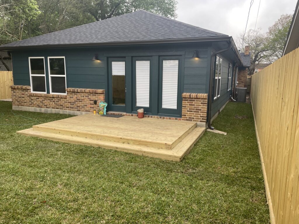 Exterior of a house with a newly built wooden deck and fence by SRP construction in Houston, TX