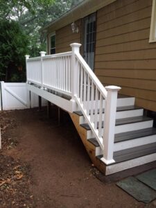 Newly constructed outdoor deck stairs with white railings, a project by Byrd's Contracting, LLC in Bristol, CT.