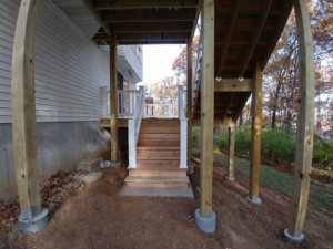 A newly constructed outdoor deck with wooden stairs and white railings, built by Custom Remodeling Inc. in Houston, TX.