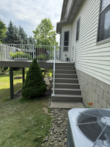 A newly constructed deck with white railings and stairs by Horstman Construction in Erie, PA.