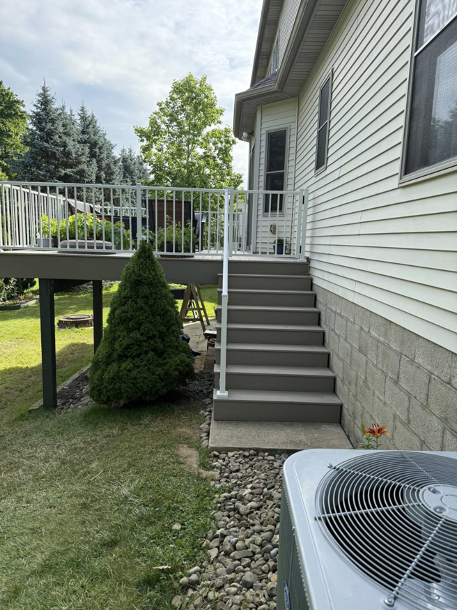 A newly constructed deck with white railings and stairs by Horstman Construction in Erie, PA.
