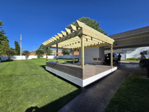 A newly constructed deck with a wooden pergola in a backyard by IWork Home Services in Greensboro, NC.