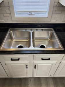 A newly installed double stainless steel kitchen sink, ready for faucet installation by Aaron's Handyman Service in Tucson, AZ.