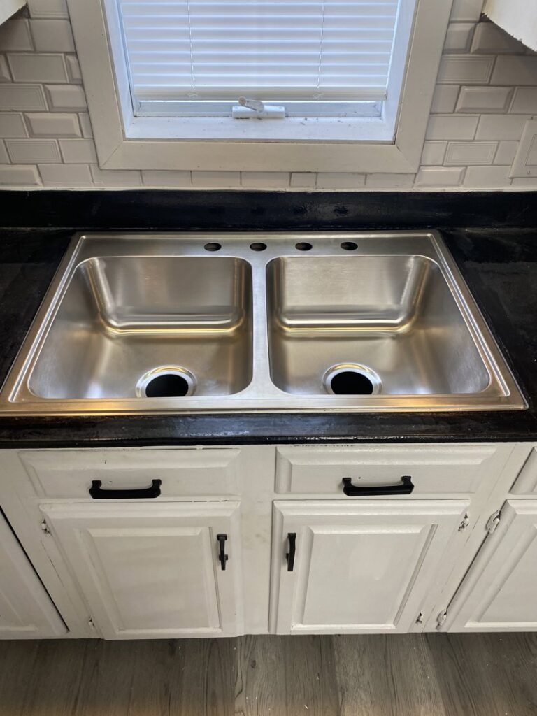 A newly installed double stainless steel kitchen sink, ready for faucet installation by Aaron's Handyman Service in Tucson, AZ.