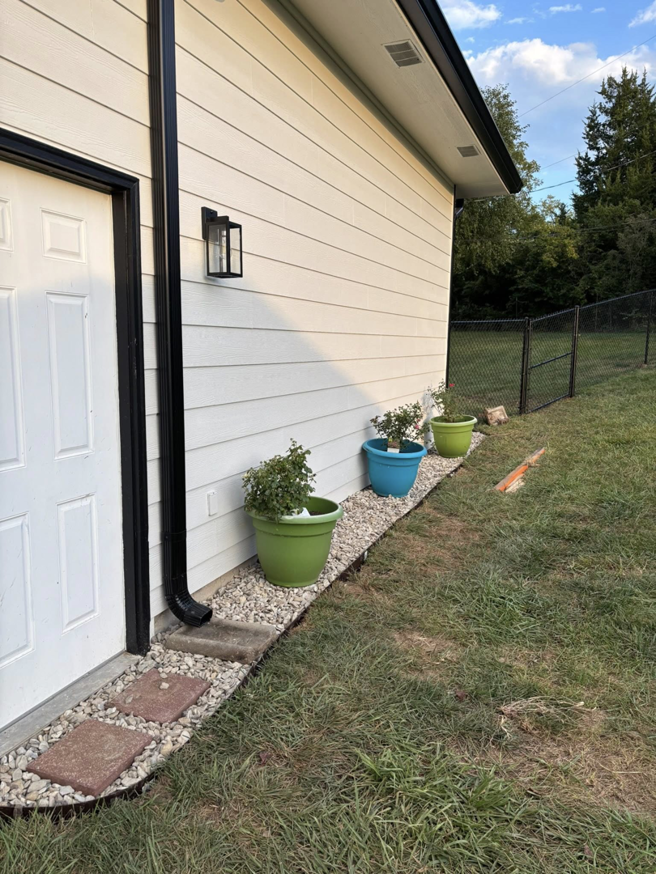 New downspout, outdoor light fixture, and gravel path with stepping stones installed by MHK Yard & Gravel in Manhattan, KS