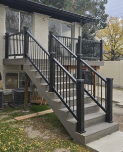A newly constructed exterior deck and staircase with modern black railings by Halpin Hands in Williams, OR.