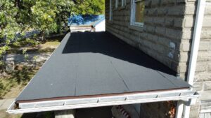 A newly installed flat roof section with a clean gutter system by Element Enterprises in Kansas City, MO.
