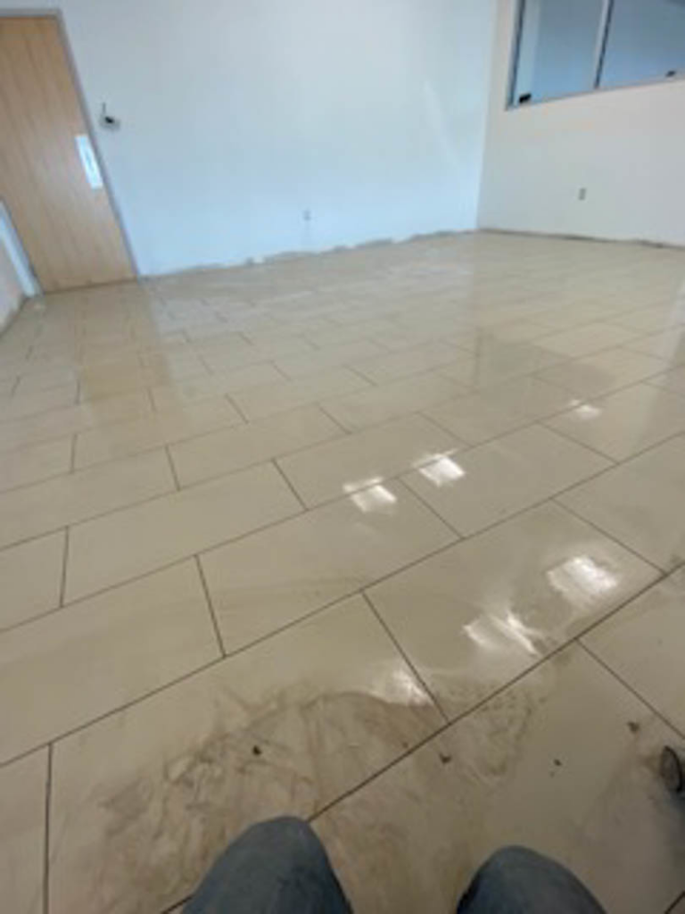 Newly installed light-colored rectangular floor tiles in a room by Infinite Construction LLC in Bristol, CT.