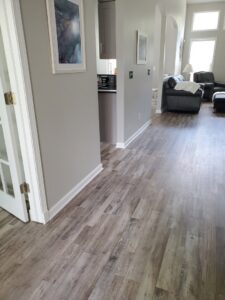 Newly installed wood-look plank flooring and crisp white baseboard trim by CLE Remodeling Co in Cleveland, OH.