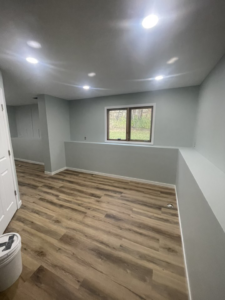 A room with new wood-look flooring, fresh light blue paint, and baseboards installed by K&T PRO Painting in St. Cloud, MN.
