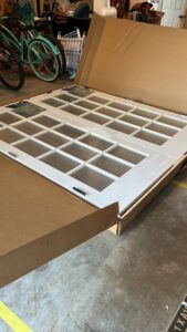 New white French doors with glass panels still in their packaging, ready for installation by Bull River Handyman in Savannah, GA.