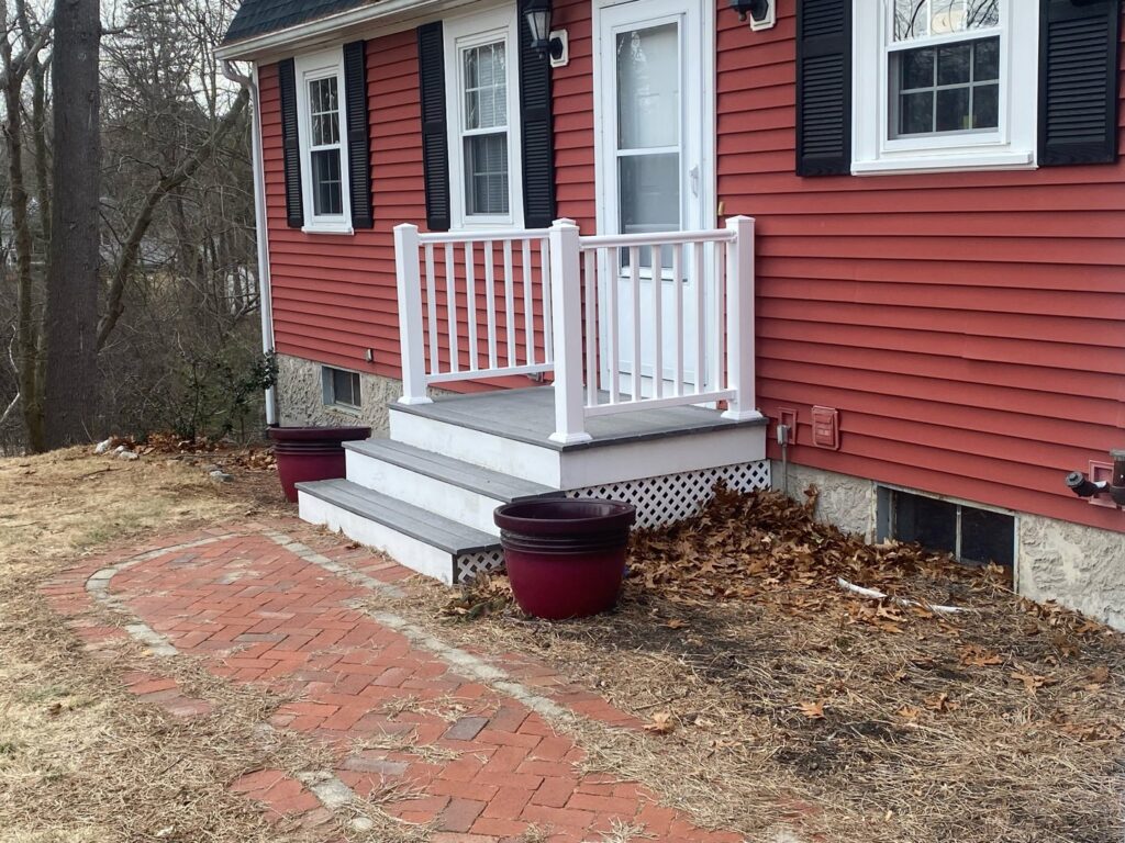 Newly installed front steps and white railing on a house exterior by CWS Handyman LLC in Seekonk, MA