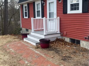 Newly installed front steps and white railing on a house exterior by CWS Handyman LLC in Seekonk, MA