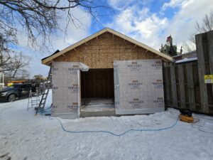 A new garage building under construction, showing wood framing and exterior sheathing wrap by Ben Nye The Fix-It Guy in Erie, PA.