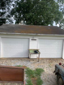 Newly installed white garage doors by Dream Construction in Johnson City, TN, enhancing home curb appeal.