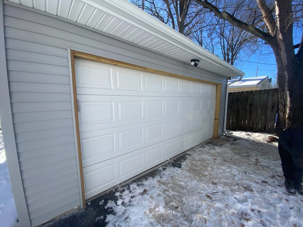 A newly installed garage door and siding on a garage, a completed renovation by Handy Fix Co. in Cleveland, OH.