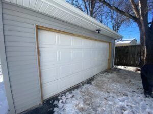 A newly installed garage door and siding on a garage, a completed renovation by Handy Fix Co. in Cleveland, OH.