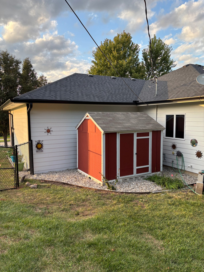 Newly installed gutters, a red shed, and gravel landscaping completed by MHK Yard & Gravel in Manhattan, KS