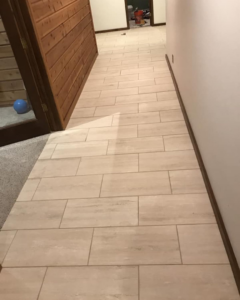 A newly installed tile floor in a hallway by D&J's Construction Services LLC in Denver, CO.