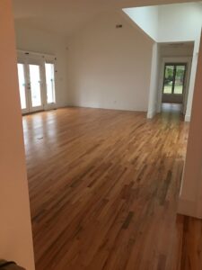 An empty room showcasing a newly installed light hardwood floor by Franco's Hardwood Flooring in Durham, NC.