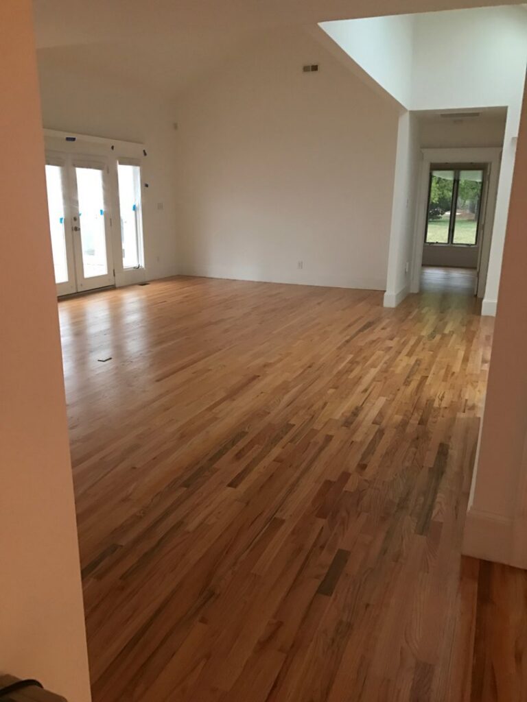 An empty room showcasing a newly installed light hardwood floor by Franco's Hardwood Flooring in Durham, NC.