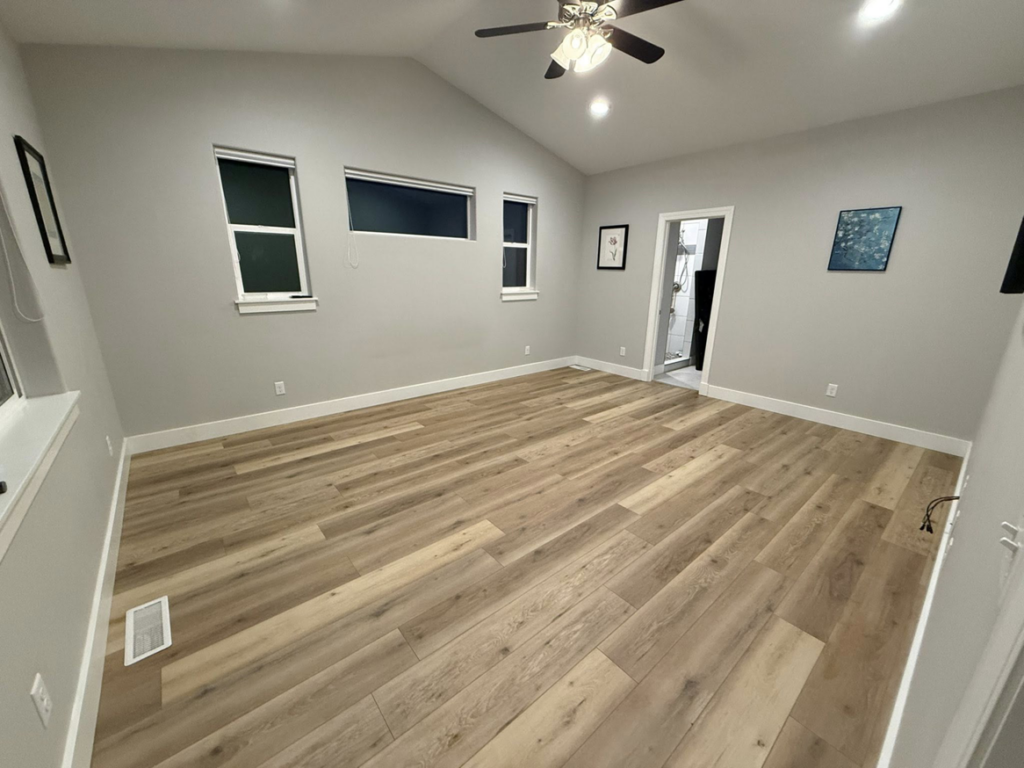 A newly installed hardwood floor and painted walls in a room by JJ's Handyman Service in Las Vegas, NV