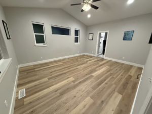 A newly installed hardwood floor and painted walls in a room by JJ's Handyman Service in Las Vegas, NV