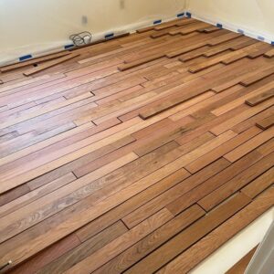 New hardwood planks laid out and ready for installation, with walls protected, by NV Floors LLC in Pittsburgh, PA.