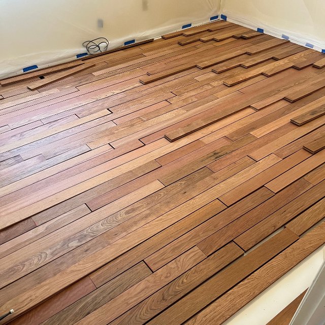 New hardwood planks laid out and ready for installation, with walls protected, by NV Floors LLC in Pittsburgh, PA.