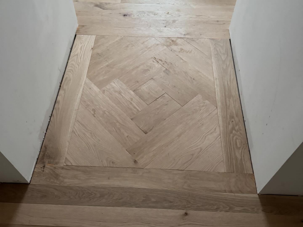 A newly installed herringbone pattern hardwood floor by Heritage Floors of Hanover LLC in Mechanicsville, VA.