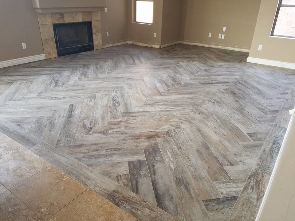A newly installed wood-look tile floor in a herringbone pattern by Clayton Family Tile, LLC in Chandler, AZ