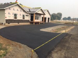 A new home construction project with a freshly paved asphalt driveway, completed by TPF Services in Yakima, WA.