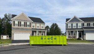 A green Broco Waste & Recycling dumpster at a new home construction site in Warminster, PA.