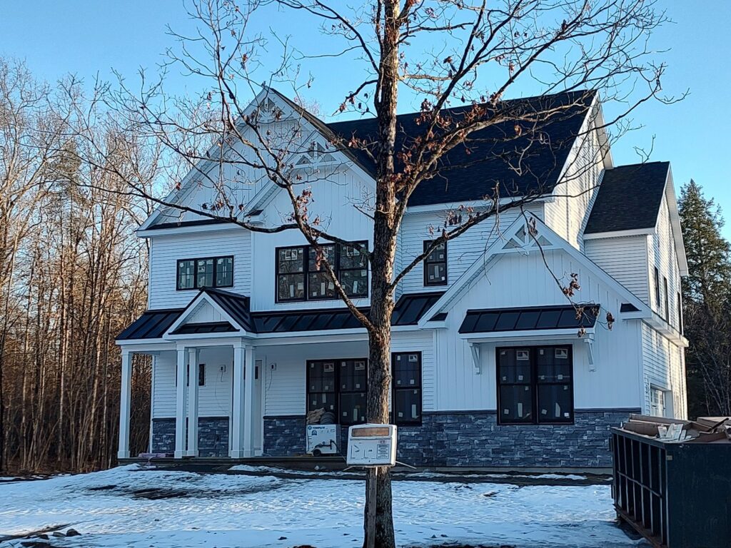 New home construction exterior with white siding and stone veneer by JB Home Improvement Services in Sanford, FL.