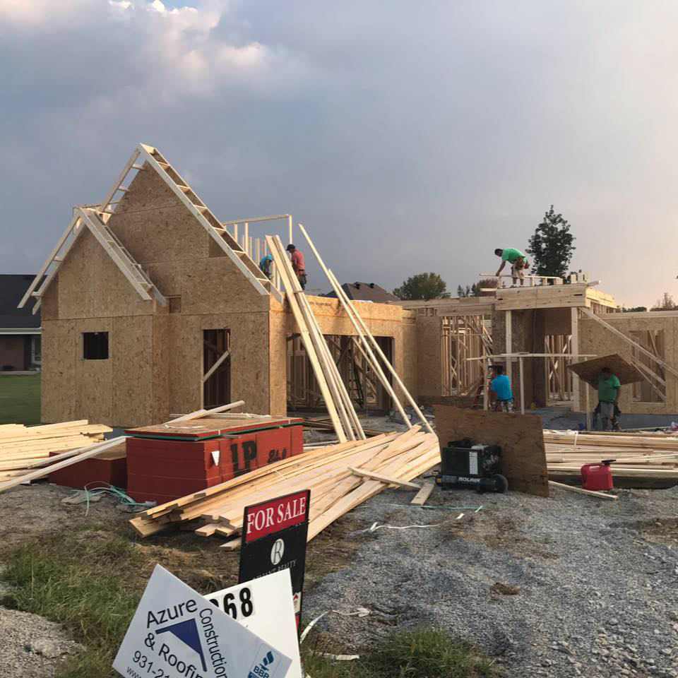 New home construction with wood framing and workers on site by Azure Construction in Clarksville, TN