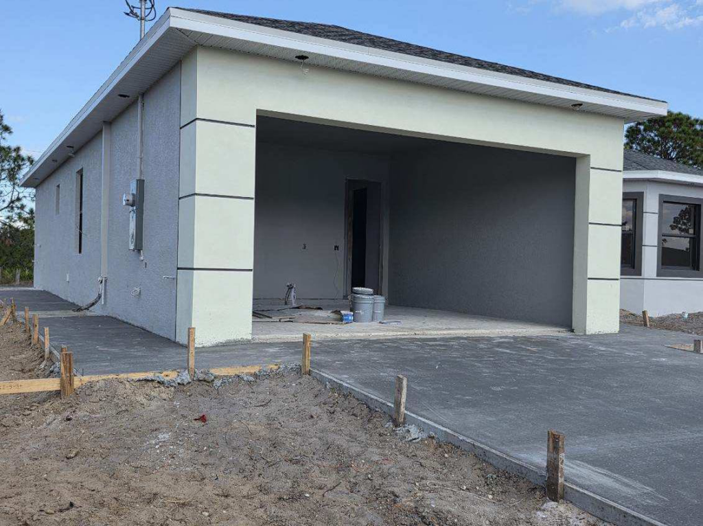 New home construction showing the garage and concrete driveway by C.A Tano Construction & Appliances Cgc1531664 in Cape Coral, FL.