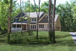 A newly constructed home with gray siding and stone accents, built by Lancaster Home Builders in Lancaster, PA.