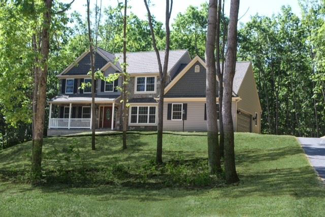 A newly constructed home with gray siding and stone accents, built by Lancaster Home Builders in Lancaster, PA.