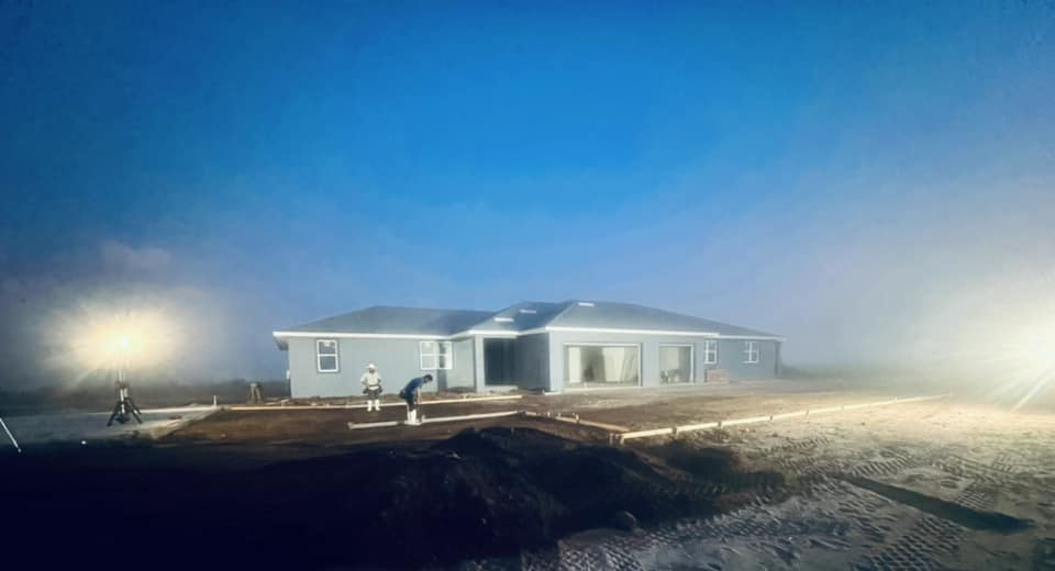 An early morning view of a new home construction site with workers by Cogdill Builders of Florida in Tampa, FL.