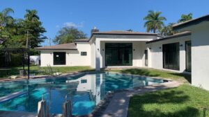 A newly constructed modern home with a swimming pool in the backyard by Florida Palm Construction, Inc. in Davie, FL