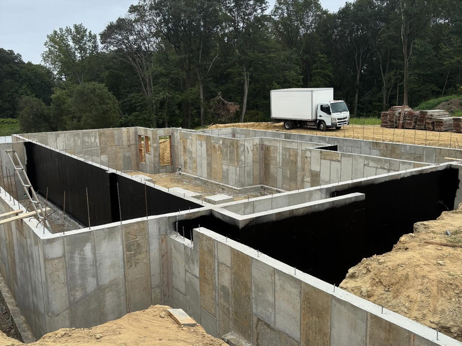 A new home foundation with black waterproofing membrane applied by ProSeal Waterproofing in Naugatuck, CT.