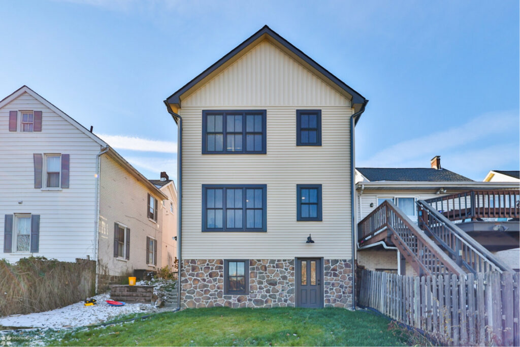 The exterior rear of a newly constructed or renovated house with new siding and stone foundation by Shafer Construction, LLC in Bethlehem, PA.