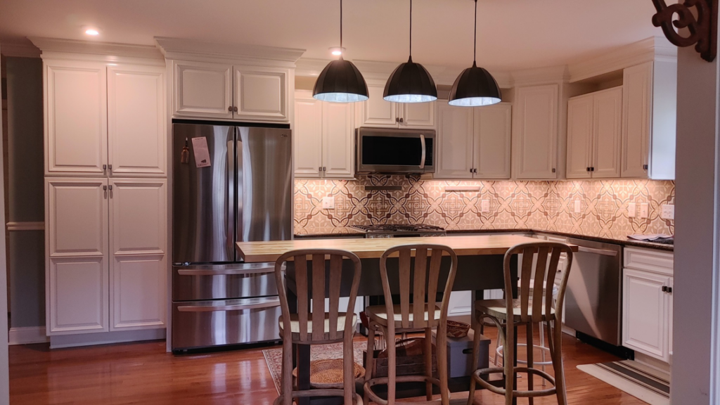 A newly installed kitchen with white cabinets and a tiled backsplash by Just Ducky Painting and Drywall Repair in Pegram, TN.