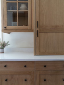 Professional installation of new wooden kitchen cabinets and a white countertop by Tusk Builders in Minneapolis, MN.