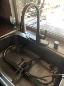A newly installed kitchen faucet in a sink, completed by Mancusi Home Maintenance in Boulder City, NV.