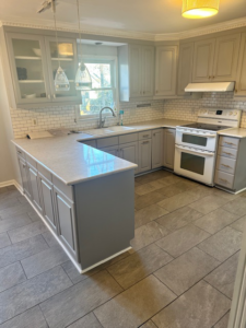 A beautifully completed kitchen remodel featuring new grey cabinets, white subway tile backsplash, and floor tiles by Bryder Construction in Greenville, SC.