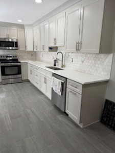 A newly renovated kitchen featuring a hexagonal tile backsplash and gray tile flooring by Extra Mile Tile in Cincinnati, OH.